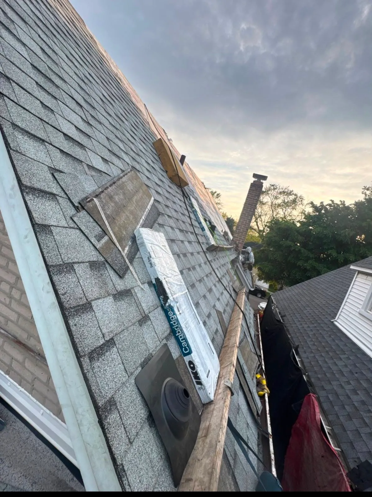 The same roof finished with new grey shingles and a new pipe boot