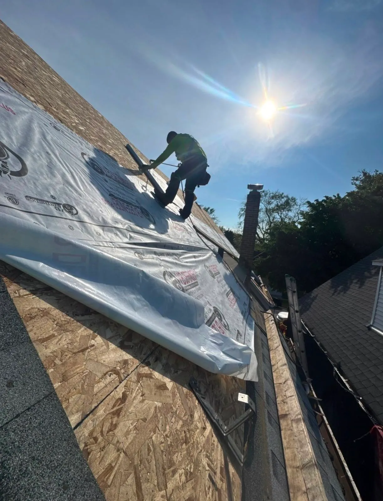 Roof stripped to bare decking with synthetic underlayment being installed